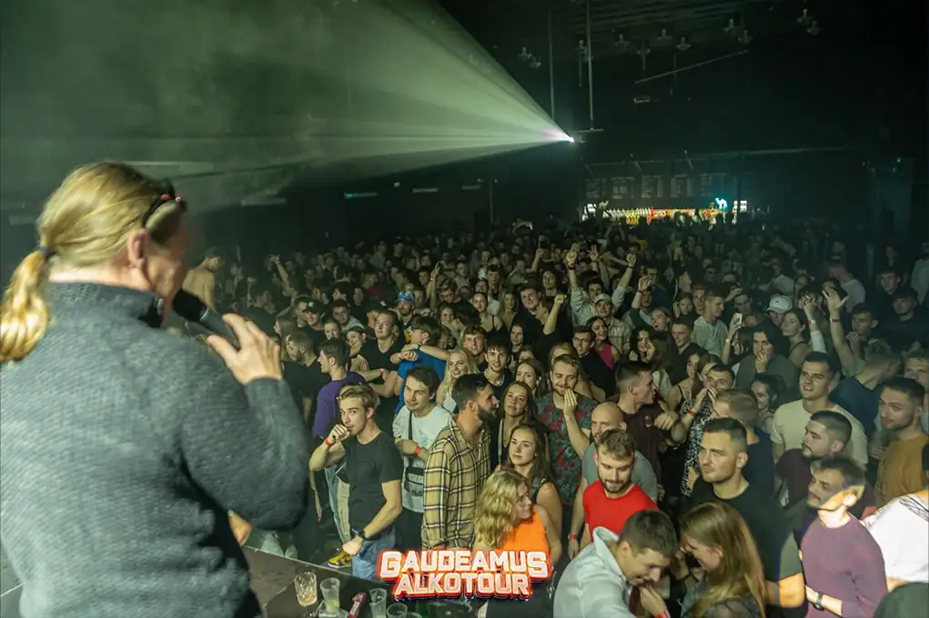 Moderátor s mikrofonem před plným sálem